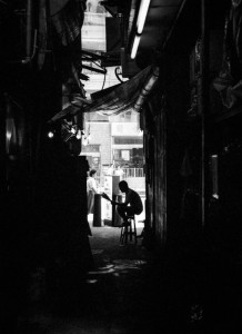 Reading Paper Whilst in Kowloon, Hong Kong I saw this man casually reading a newspaper at the end of a narrow path between two buildings. It made for a nice silhouette.