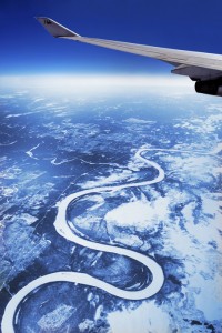 Siberian River If I am on a long flight over interesting or unfamiliar countries I always try to get a window seat with a view. I have missed a lot of sleep just watching the passing landscapes. This photograph was taken on a Japan Airlines flight to Europe which passed over Siberia. It needed a lot of editing as the double window diffracted the light badly, causing undesirable moire effects. I felt it was worth the effort.