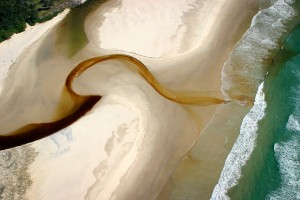 Short Cut Tea tree stained water flowing to the ocean at Belongil Beach, North of Byron Bay NSW